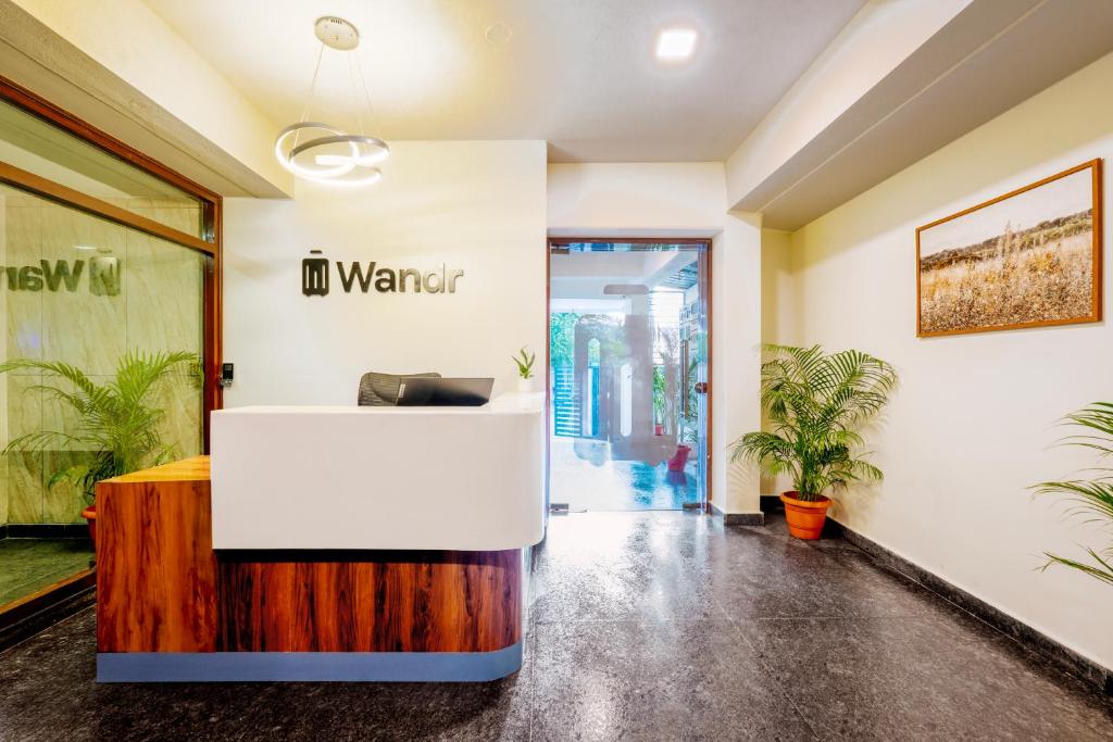 an office with a waiting room with a sign on the wall at Wandr Hotel Brookefield, Bangalore in Bangalore