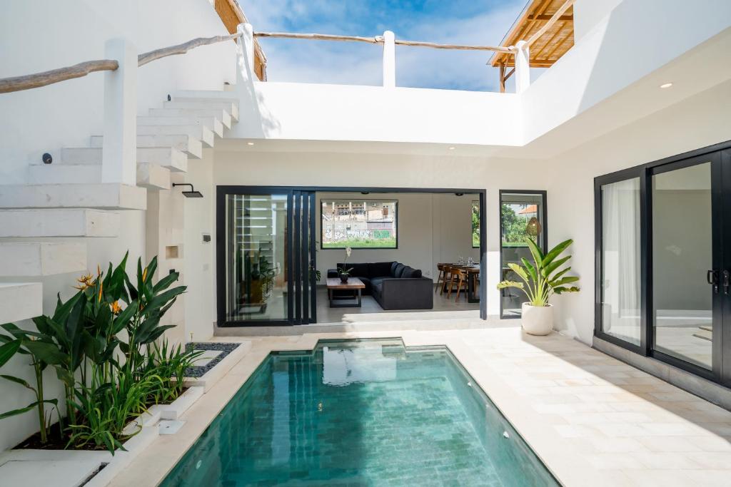 a swimming pool in a house with a living room at Villa Onetti - Luxury Villa with Private Pool, Rooftop & Rice Field Views in Tumbak Bayuh