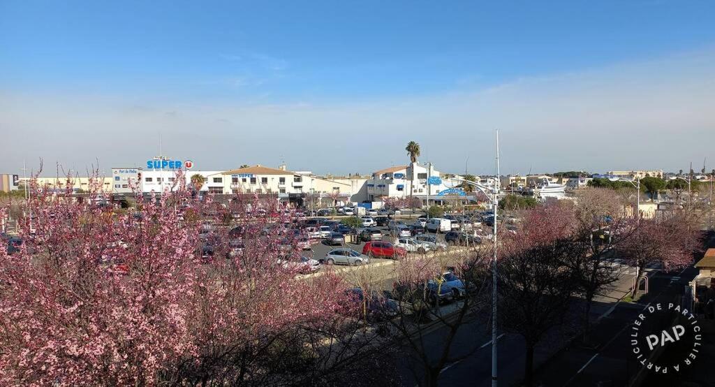 une ville avec des voitures garées dans un parking dans l'établissement Studio Cabine Climatisé tout près de la plage, au Grau-du-Roi