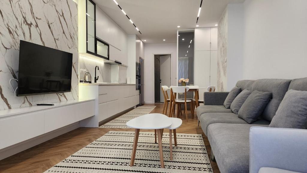 a living room with a couch and a tv and a table at Blue sand apartments in Golem
