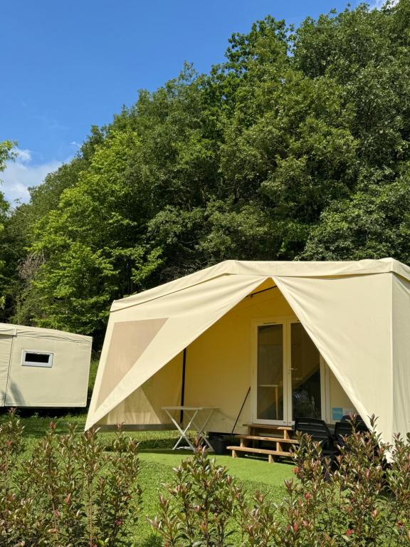 una grande tenda in un campo con alberi sullo sfondo di Camping Familial - Parc Aquatique - Grande Aire de Jeux à la Montagne ad Agos-Vidalos
