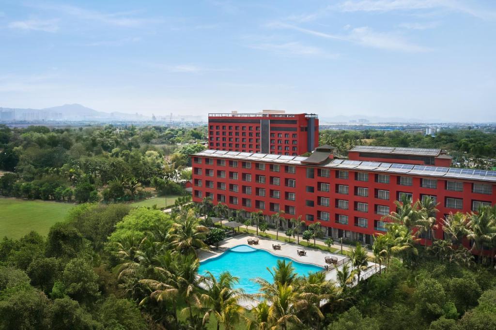 widok z góry na czerwony budynek z basenem w obiekcie Saya Grand Resort By Treat Thane w mieście Dive