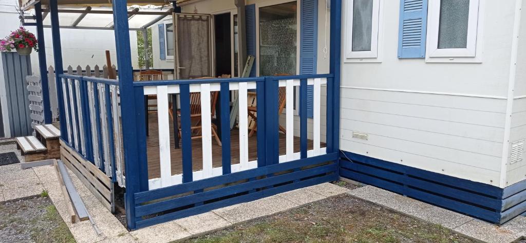 une terrasse couverte avec une balustrade bleue sur une maison dans l'établissement Mobil-home, à Capbreton