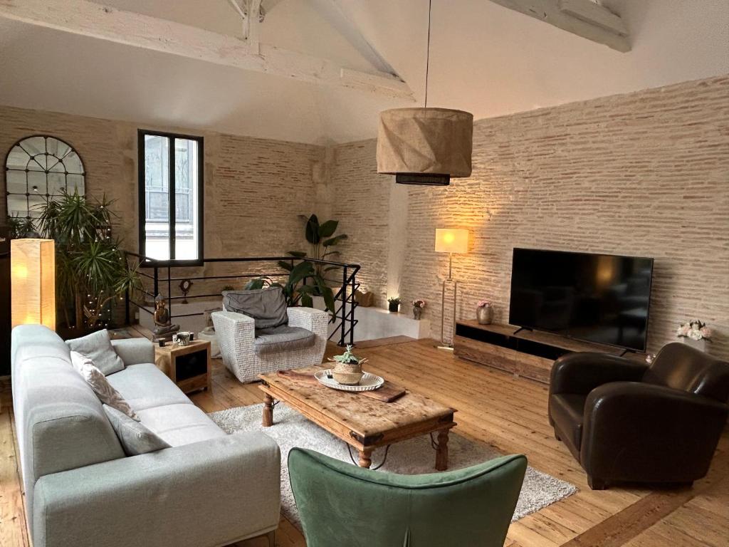 un salon avec un canapé, des chaises et une télévision dans l'établissement Aloha, à Arcachon