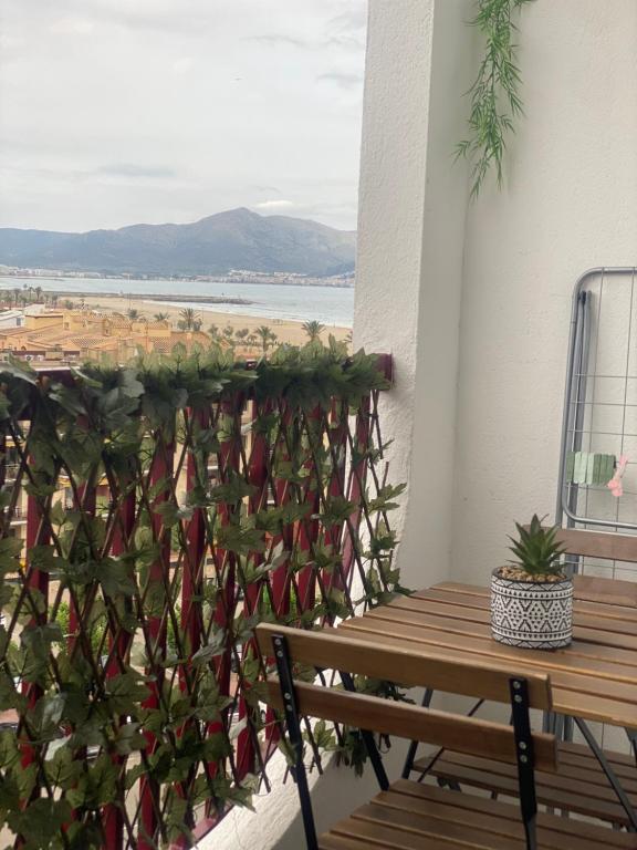 Un balcón con una mesa de madera y una planta en Apartamento en frente al mar de Empuriabrava, en Empuriabrava