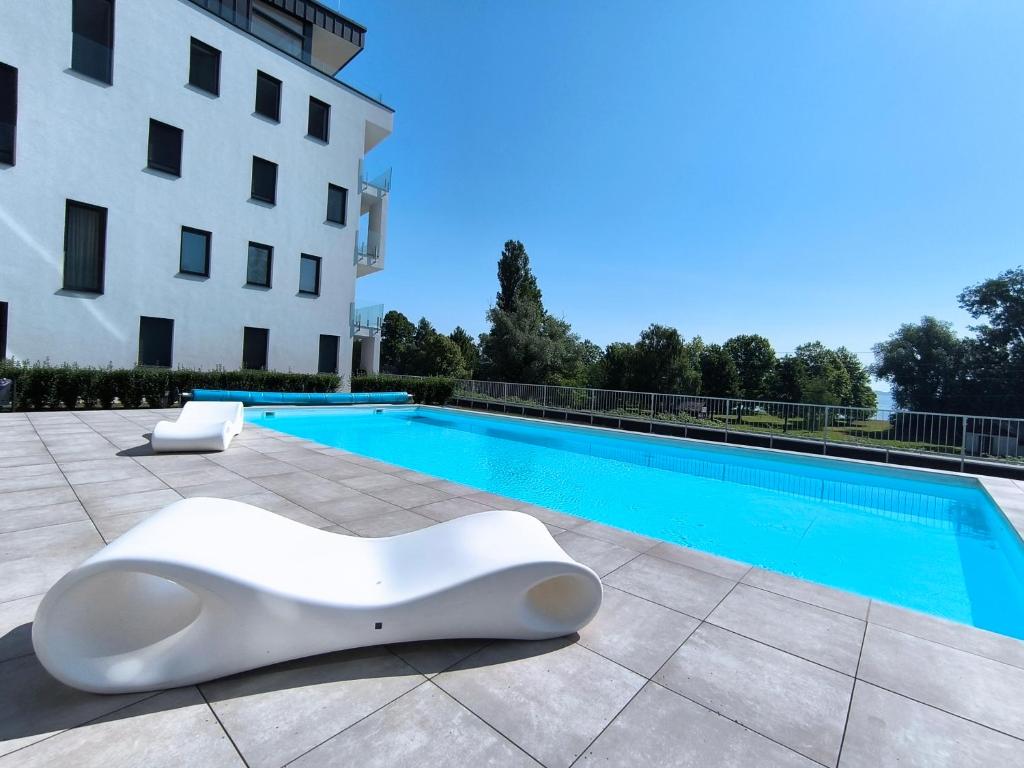 una scultura bianca seduta accanto a una piscina di Helikon Beach Apartment a Keszthely