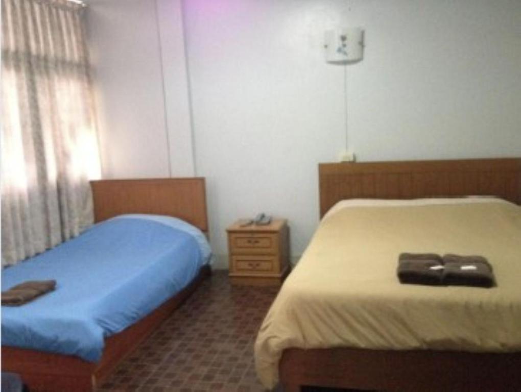 Giường trong phòng chung tại White Orchid Inn II