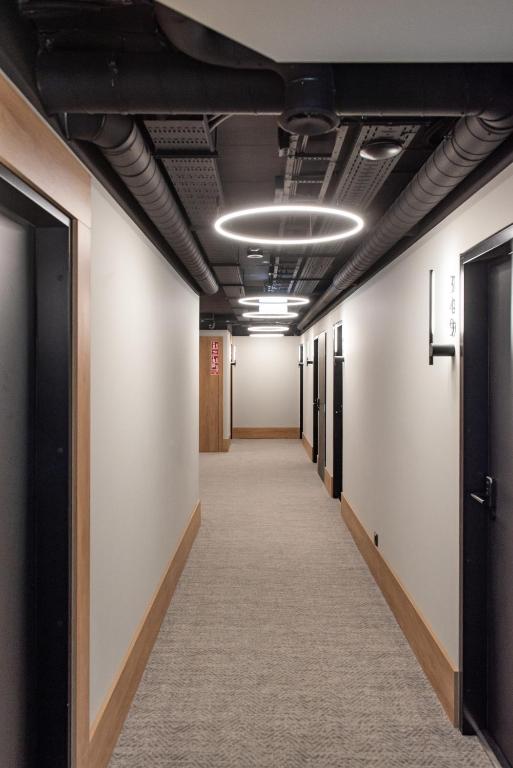 an empty corridor in an office building with a hallway at AIRINN Vilnius Airport Hotel RENOVATED 2025 in Vilnius