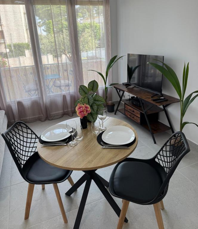 une table à manger avec deux chaises et une table avec des verres dans l'établissement magnifique T2 calme bord de mer, à La Ciotat