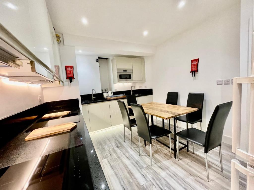 eine Küche und ein Esszimmer mit Tisch und Stühlen in der Unterkunft Luxe Villa, 5 En-suite Bedrooms - West London - Wembley Stadium 5KM away in Harrow on the Hill