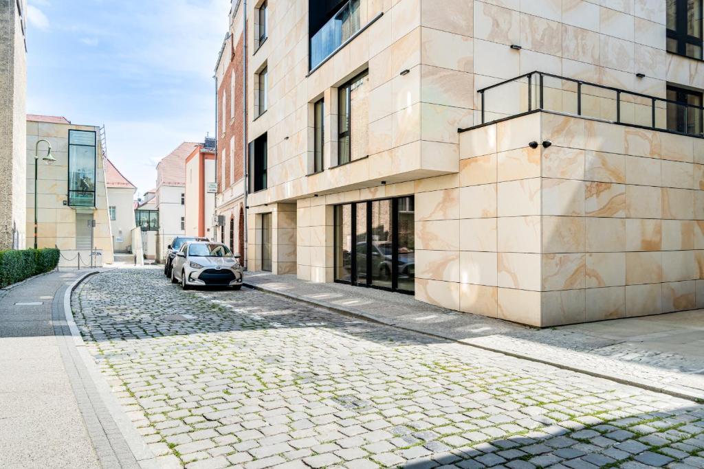 オポーレにあるMuzealna Business Roomsの建物横の石畳の通りに駐車した車