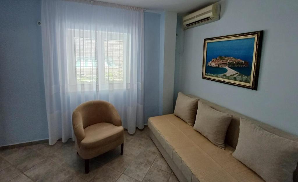 a living room with a couch and a chair at Apartments Mitrovići Miločer in Sveti Stefan