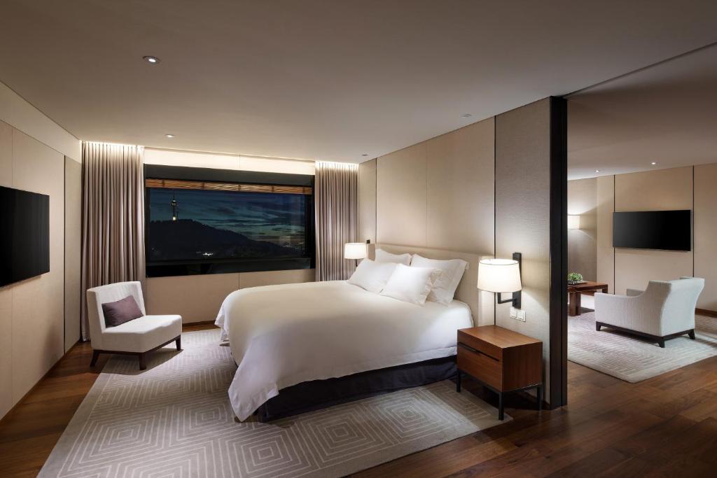 a bedroom with a white bed and a large window at The Shilla Seoul in Seoul
