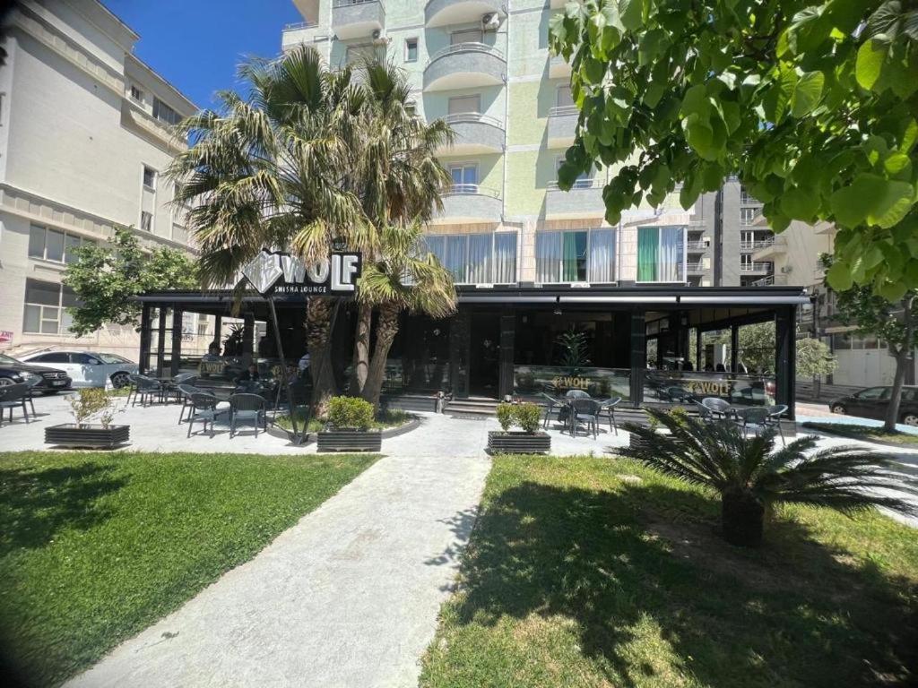 a building with a pavilion in the middle of a park at Arber Premium Apartment in Durrës