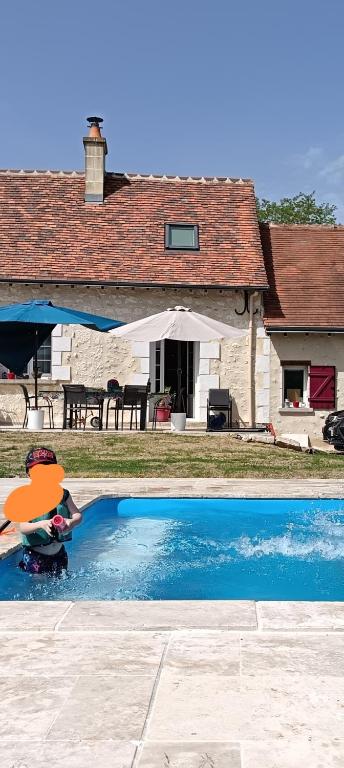 une maison avec une piscine devant une maison dans l'établissement Longère proche du zoo de Beauval et des châteaux de la Loire, à Loches