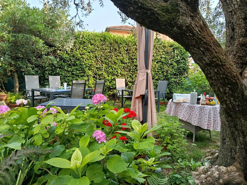 stół i krzesła w ogrodzie z kwiatami w obiekcie B&B Casa Mia w mieście Desenzano del Garda