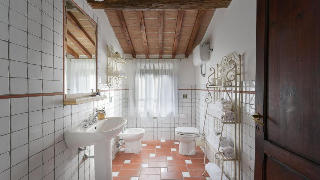 łazienka z umywalką, toaletą i lustrem w obiekcie VILLA GINESTRAIO 8, Emma Villas w mieście Palaia