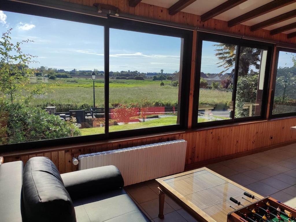 Cette chambre comprend un canapé, une table et des fenêtres. dans l'établissement 10-person gîte in Barfleur, à Barfleur