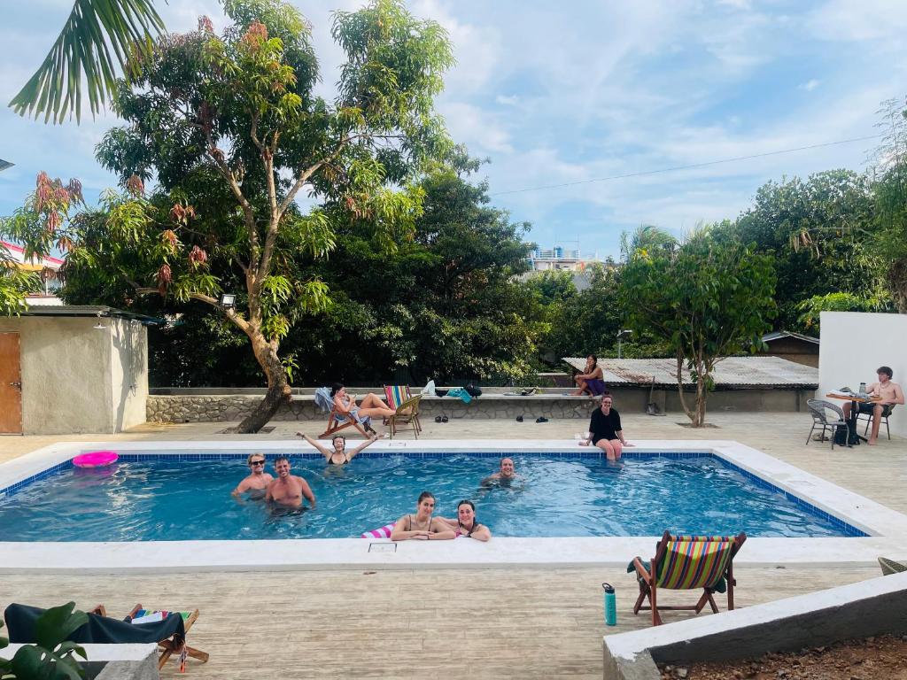 a group of people sitting in a swimming pool at Green Gecko Pool Hostel and 3 Day Expedtion in Coron