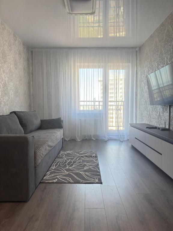 a living room with a couch and a television at Жемчужина 59 in Odesa