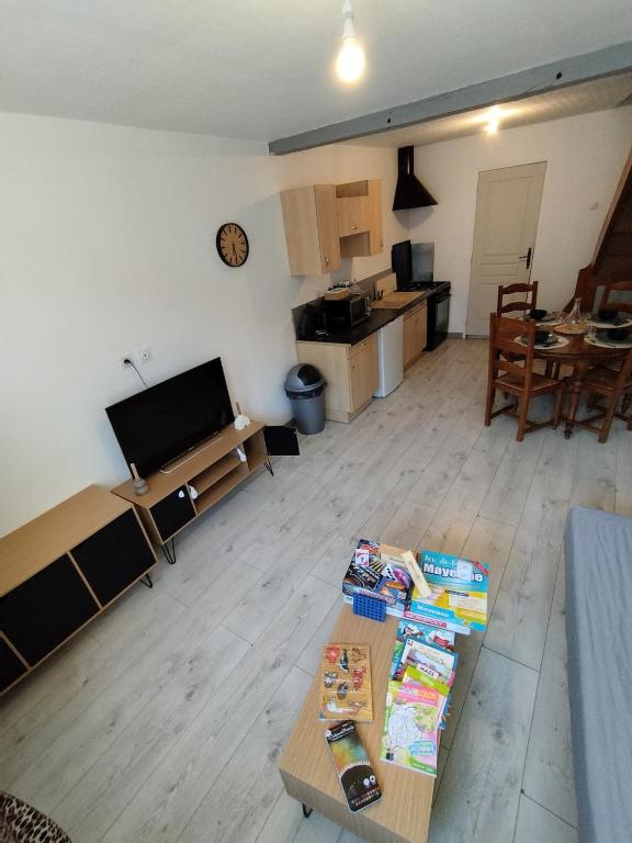 un salon avec deux tables et une cuisine dans l'établissement Jolie maison centre Ernée, à Ernée