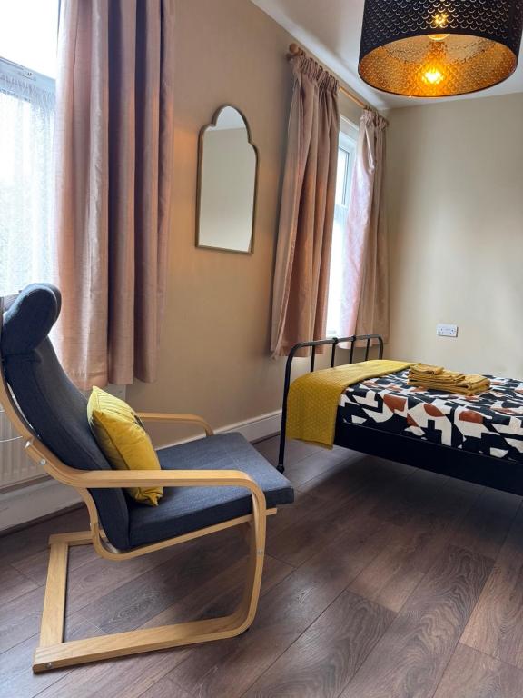 a bedroom with a bed and a chair in it at Rectory Cottage in Croydon