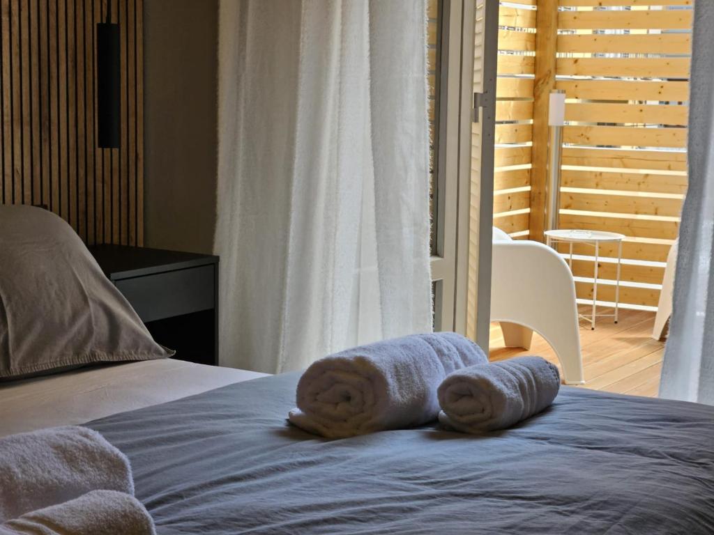 a bed with towels sitting on top of it at Be Your Home - Guest House Montegrappa Terrace in Civitavecchia