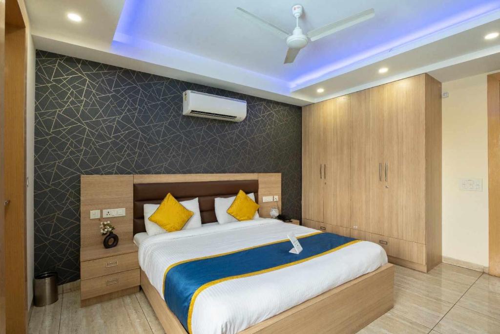 Un dormitorio con una cama grande con almohadas amarillas. en Hotel Blue Neck Hudda City Centre Fortis Hospital, en Gurgaon