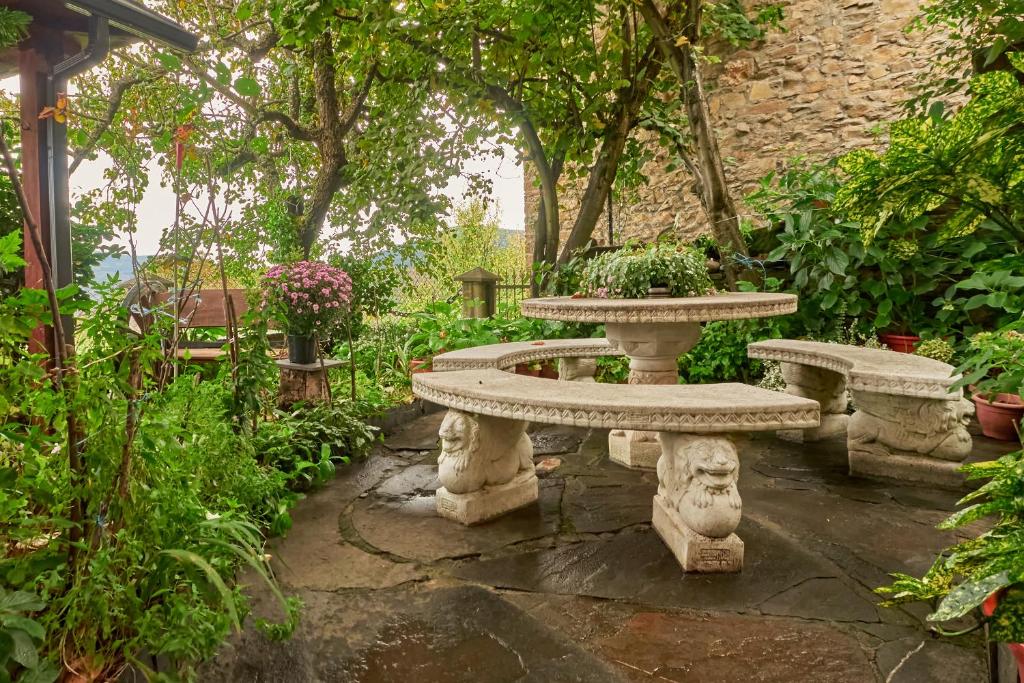 a stone table and bench in a garden at Casa Rural Tio Eloy in Fabero