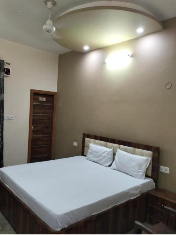 a bedroom with a large bed with white sheets at Vishal Homestay in Rāja Sānsi