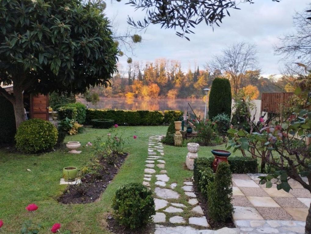 un jardin avec un chemin en pierre dans la pelouse dans l'établissement Les quatre saisons, à Bergerac