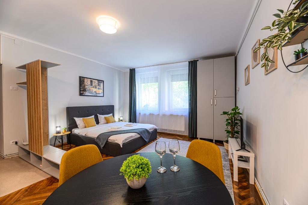 een slaapkamer met een bed, een tafel en stoelen bij Studio Modern 10 in Braşov