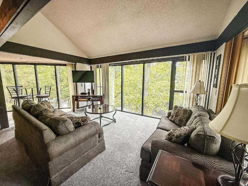 Una sala de estar con dos sofás y una gran ventana. en Treehouse Treetop Village101-3bed3bapools-8pp, en Four Seasons