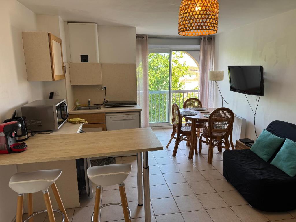 une cuisine et un salon avec une table et des chaises dans l'établissement Studio Cosy à Carnon-Plage, à Carnon-Plage