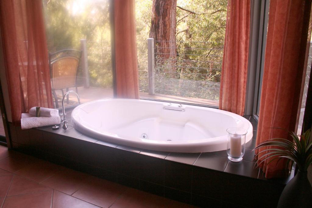 a bath tub sitting in front of a window at Heavenly Retreat in Halls Gap