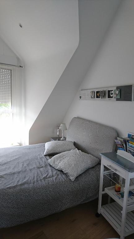 une chambre blanche avec un lit et une table dans l'établissement Ar Baradoz Bihan - studio meublé, à La Celle-sous-Gouzon