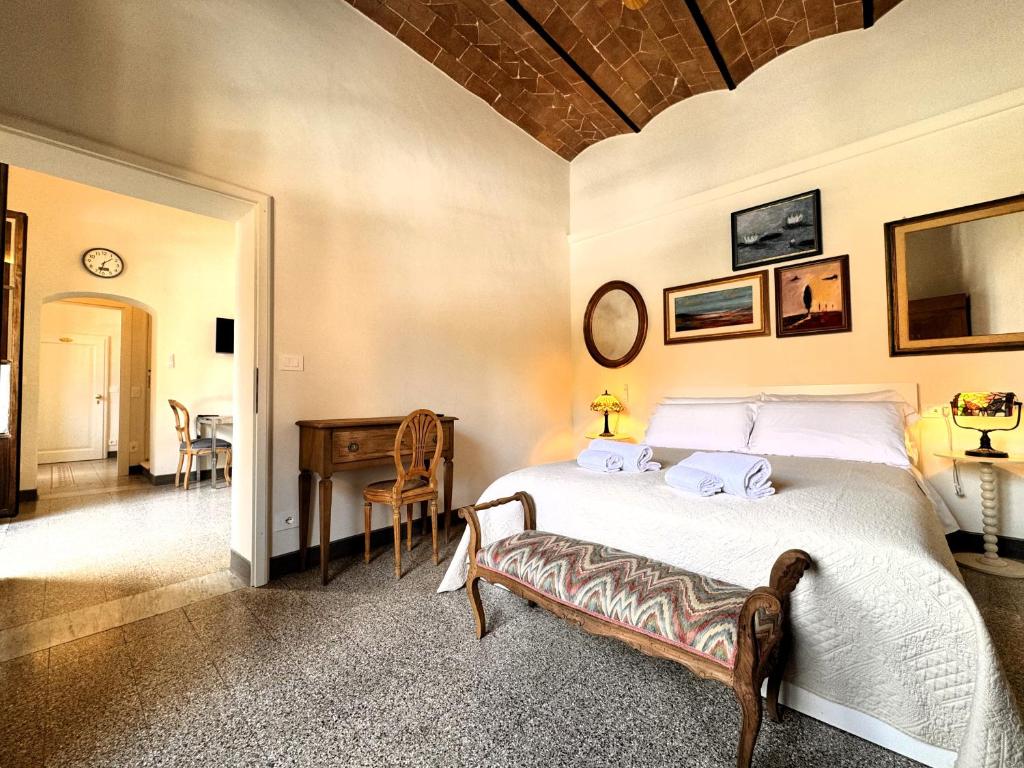een slaapkamer met een bed, een tafel en een bureau bij Affaccio su le Lupe in Siena