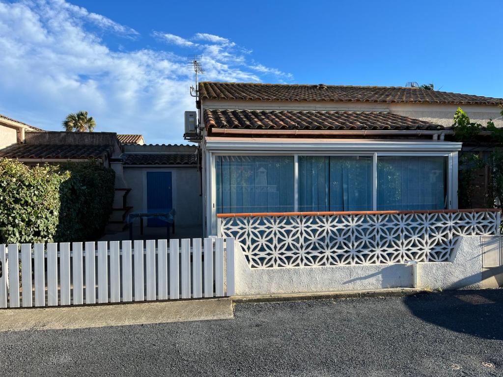 une clôture blanche devant une maison dans l'établissement Maison 3ch 250m mer - piscine - Clim, à Sainte-Marie-la-Mer