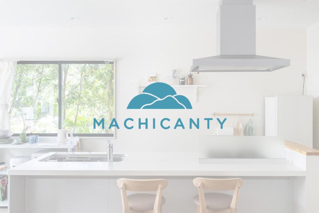 a white kitchen with a sign that reads macritis at Machicanty -まちかんてぃ- in Motobu