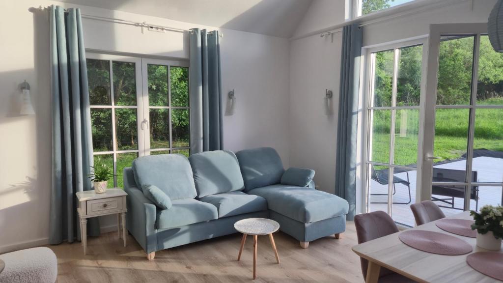 a living room with a couch and a table at Káli Pillangó - Ház a völgyben in Balatonhenye