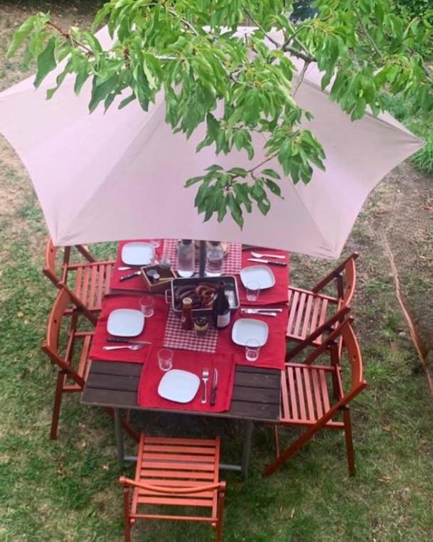 - une table de pique-nique rouge avec des chaises et un parasol dans l'établissement PALAU de CERDANYA I El Palauet, à Palau-de-Cerdagne