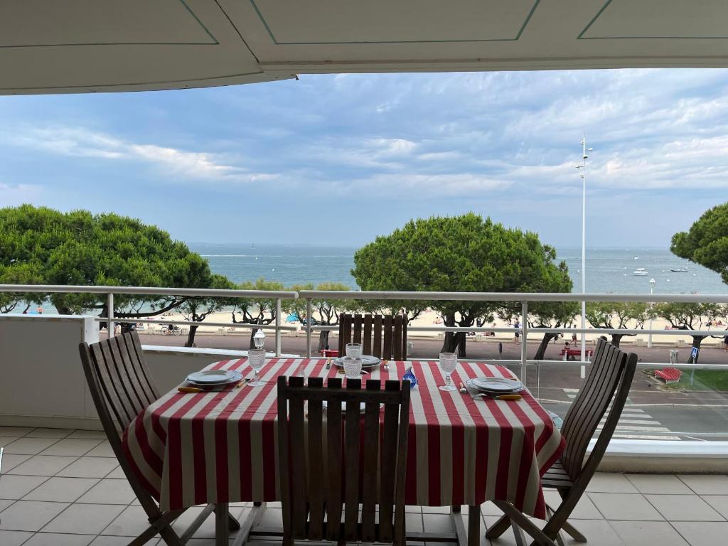 - une table avec des chaises assises sur un balcon avec vue sur l'océan dans l'établissement Appartement T3 Central à Arcachon avec Vue Mer, Terrasse, Wifi et Parking - FR-1-374-52, à Arcachon