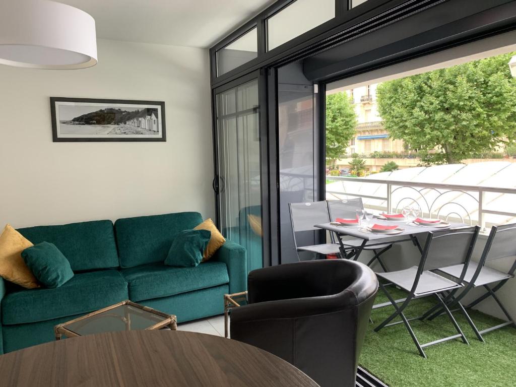 un salon avec un canapé vert et une table dans l'établissement Charmant T3 au cœur d'Arcachon, à 50m de la plage & 300m de la gare, parking et WiFi inclus - FR-1-374-121, à Arcachon