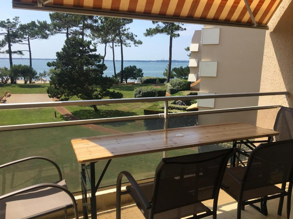 une table et des chaises sur un balcon avec vue sur l'océan dans l'établissement Appartement rénové centre Moulleau avec balcon et parking - FR-1-374-159, à Arcachon