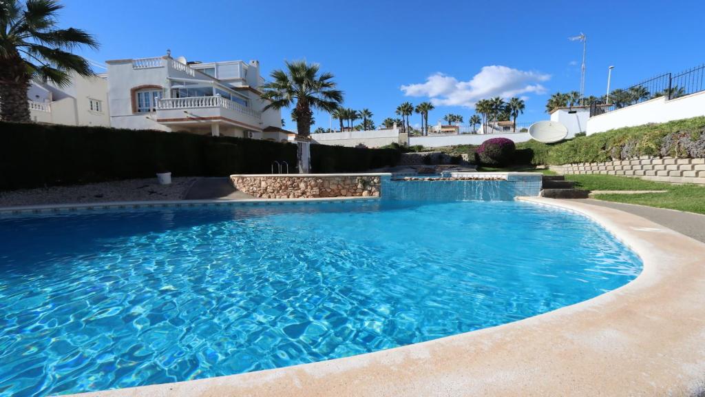 Una gran piscina azul frente a una casa en REF 7082 Apartment Los Dolses, en Los Dolses
