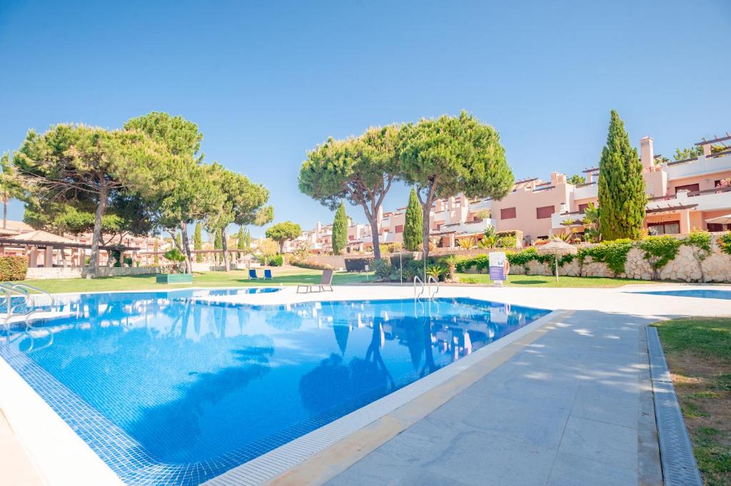 una piscina con alberi e edifici sullo sfondo di Villa Filó , Vila Sol with pool a Quarteira