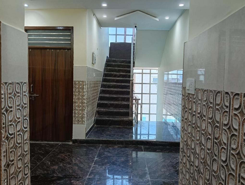 a hallway with a wooden door and a staircase at Govind Anand Dham in Vrindāvan