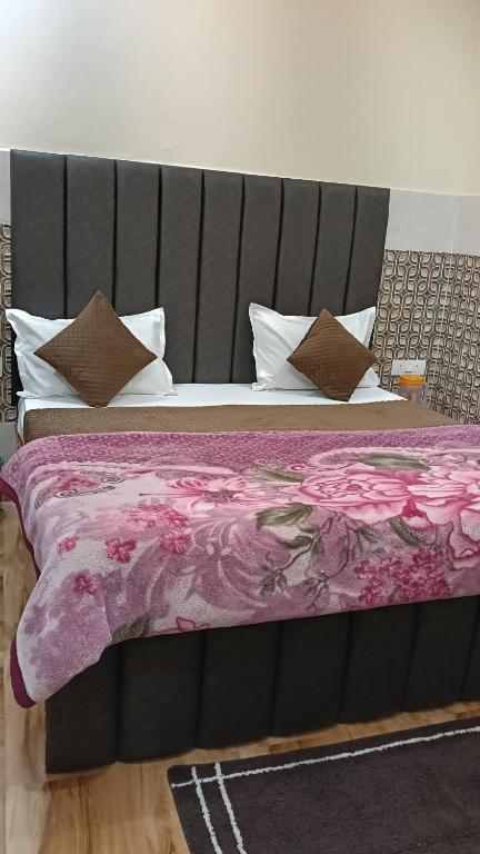 a bed with a purple blanket and pillows at Govind Anand Dham in Vrindāvan