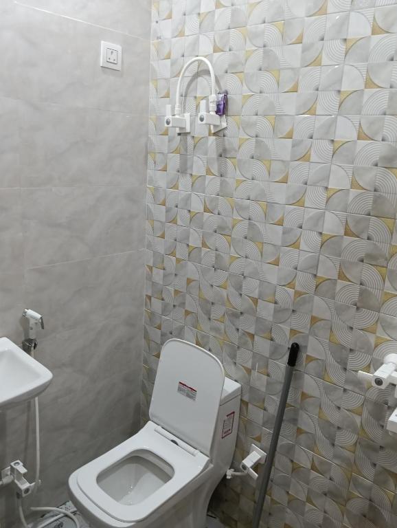 a bathroom with a toilet and a shower curtain at Govind Anand Dham in Vrindāvan