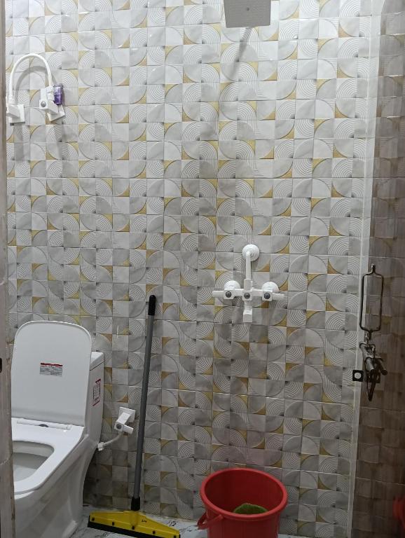 a bathroom with a toilet and a shower curtain at Govind Anand Dham in Vrindāvan